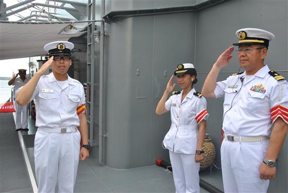 Miembros de la tripulación de uno de los buques saludan a los visitantes