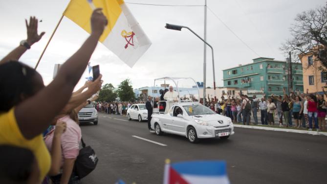 People react as Pope Francis arrives at the airport in Havana