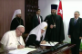 El Papa y el Patriarca sentados a la mesa firman la declaración conjunta, en presencia de Raúl Castro. Foto: Cubadebate
