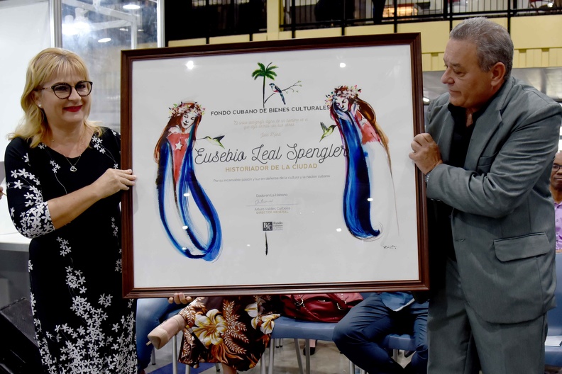 La periodista Magda Resik (I), recibe un Reconocimiento Especial otorgado a Eusebio Leal Spengler, historiador de La Habana, de manos de Arturo Valdés Curbeira, director general del Fondo Cubano de Bienes Culturales (FCBC), durante la inauguración de la XXIII Feria Internacional de Artesanía FIART 2019, que tiene por sede el recinto ferial Pabexpo, el 6 de diciembre de 2019. ACN FOTO/Omara GARCÍA MEDEROS/ogm