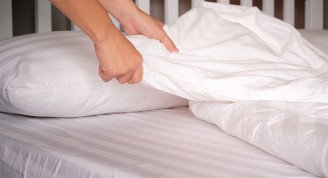 The hands of housewives who are changing sheets in hotels.