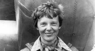 Amelia_Earhart_standing_under_nose_of_her_Lockheed_Model_10-E_Electra,_small (Mediano)